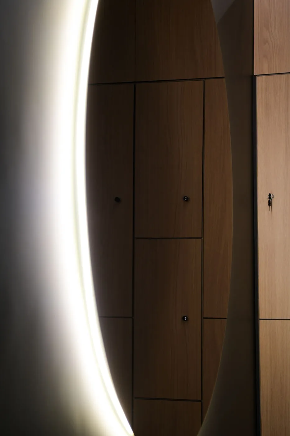 Illuminated mirror and wooden lockers at the 8D clinic