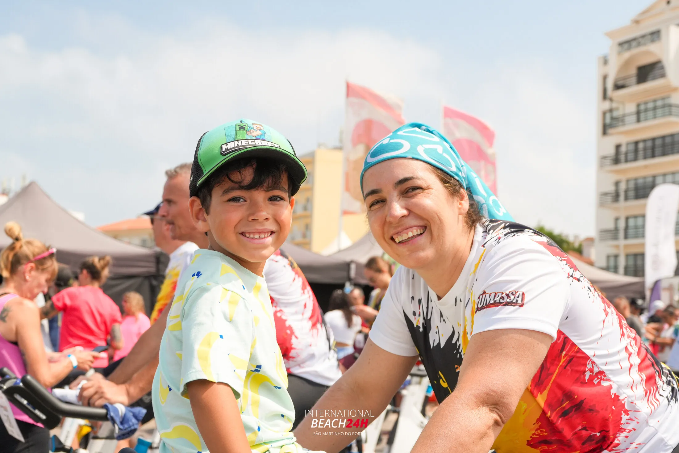 A participant and a child smiling among the bicycles at Beach24H