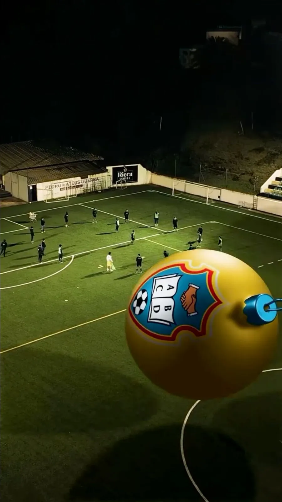 Beneditense video frame: a 3D ball with the club crest over the pitch at night