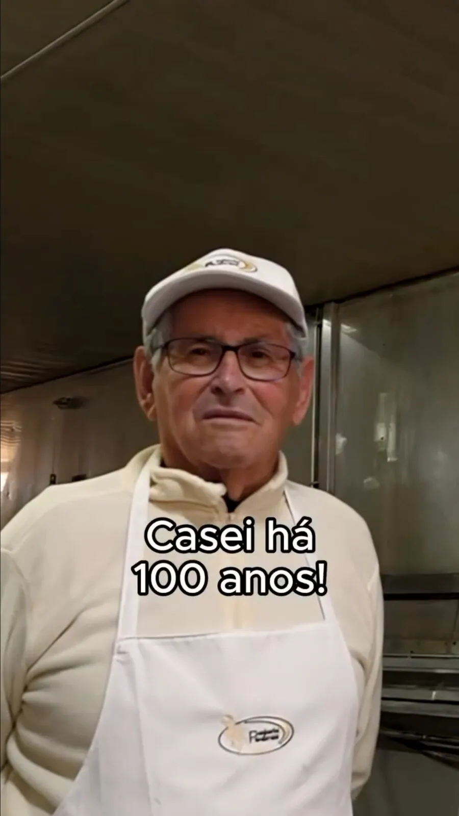 Padaria Pedras video frame: the founder in cap and apron in the bakery
